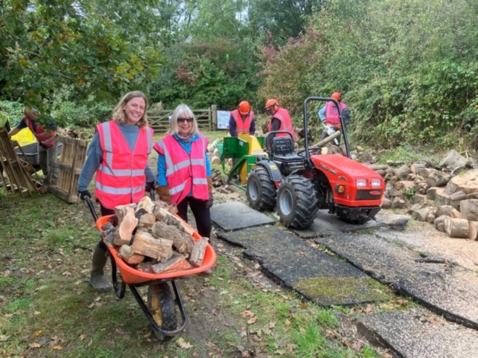 Group doing conservation work and moving logs and cutting wood