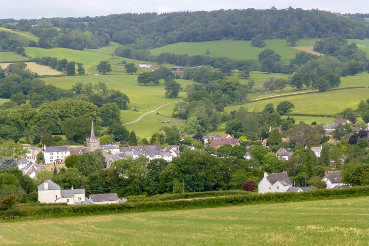 Patchwork of fields in a dip with a village in middle