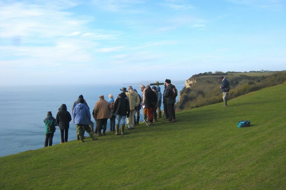 group stood looking over sea from cliff