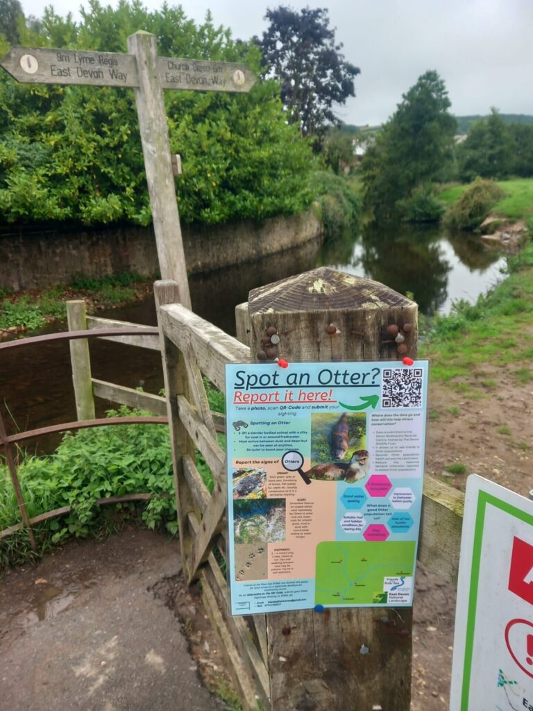 A spot an otter poster on a footpath gateway promoting people to report otters if viewed