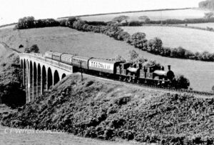 black and white photo of railway from past going over a viaduct